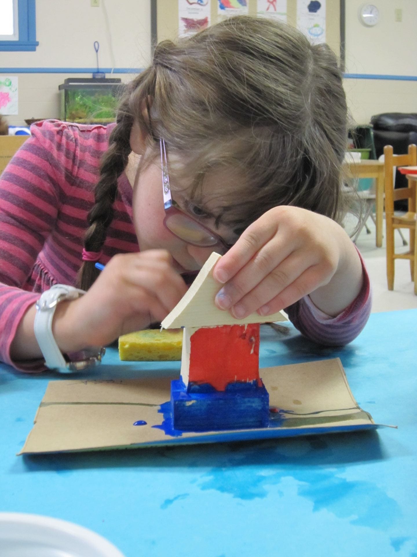 Girl paints a small wooden sculpture.